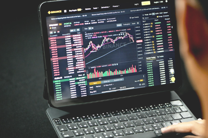 Aktienbewertungen Person betrachtet Finanzdiagramme und Marktanalysen auf einem Laptop.